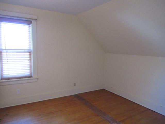 502 Park St S, Fairfax, MN 55332 - additional living space with wood finished floors, vaulted ceiling, plenty of natural light, and baseboards