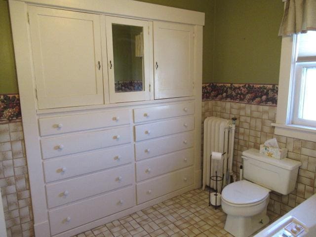 502 Park St S, Fairfax, MN 55332 - half bathroom featuring radiator, toilet, a wainscoted wall, tile walls, and tile patterned floors