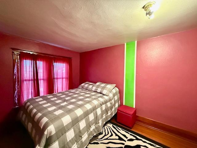 bedroom with wood finished floors and a textured ceiling