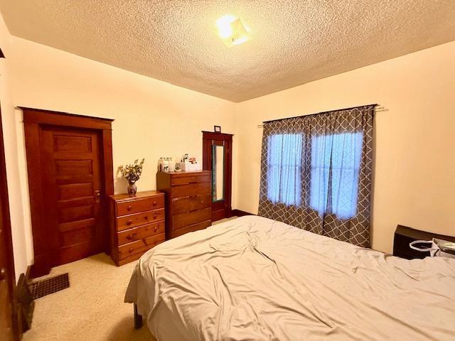 carpeted bedroom with a textured ceiling