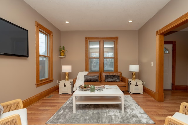 living room with light wood finished floors, baseboards, and recessed lighting