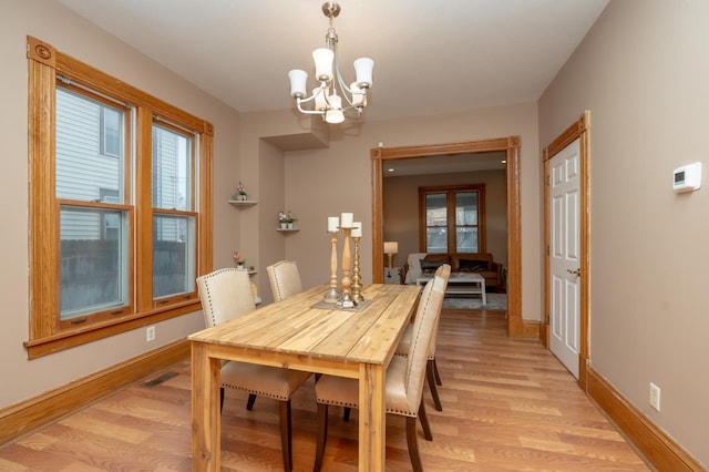 dining room featuring baseboards, an inviting chandelier, french doors, light wood-style floors, and visible vents