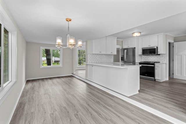 3401 Meadow Ln, Minnetonka, MN 55345 - kitchen with stainless steel appliances, a chandelier, decorative backsplash, white cabinetry, and light wood finished floors