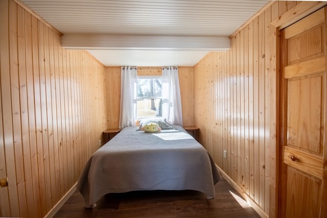 bedroom featuring wood walls, wood finished floors, and baseboards
