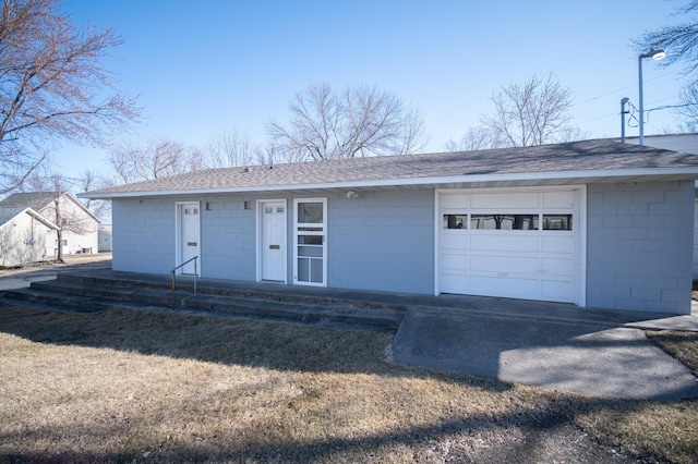 ranch-style house with concrete block siding and roof with shingles