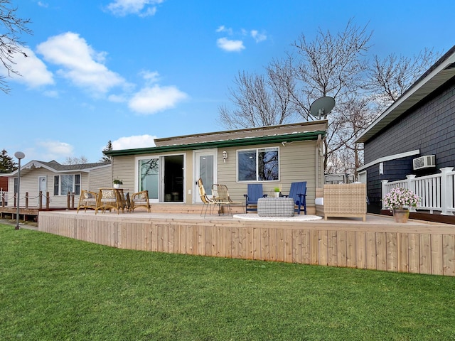 rear view of house with a wooden deck and a lawn