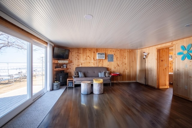 living room with wooden walls, wood finished floors, and plenty of natural light