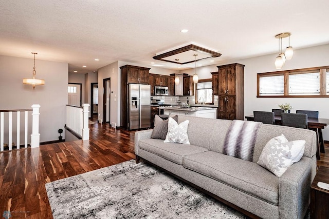 living room with dark wood-style floors, recessed lighting, and baseboards