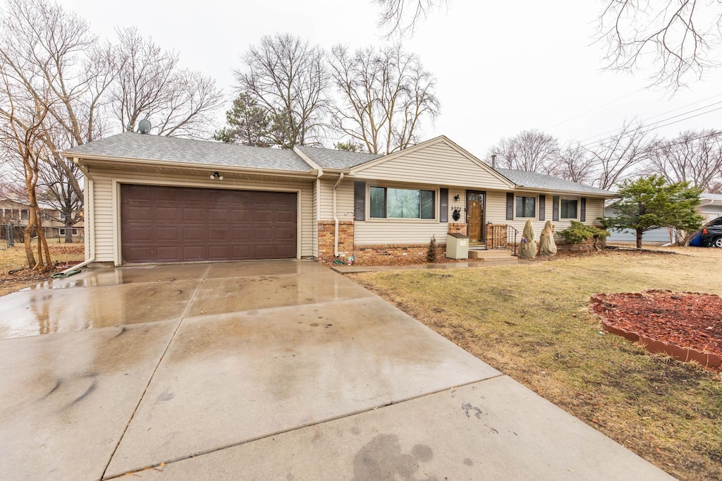 single story home featuring a front yard, concrete driveway, a garage, and a shingled roof