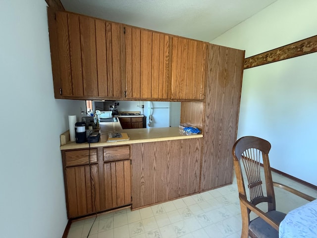 7996 Corey Path, Inver Grove Heights, MN 55076 - kitchen featuring brown cabinets, light countertops, a sink, freestanding refrigerator, and light marble finish flooring