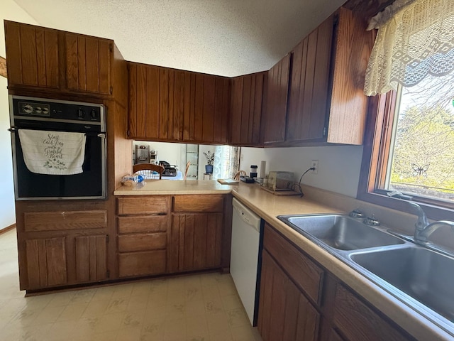 7996 Corey Path, Inver Grove Heights, MN 55076 - kitchen with oven, white dishwasher, a sink, light countertops, and a textured ceiling
