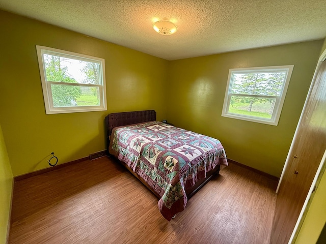 68680 470th St, Wellington Twp, MN 55332 - bedroom with wood finished floors, baseboards, and a textured ceiling