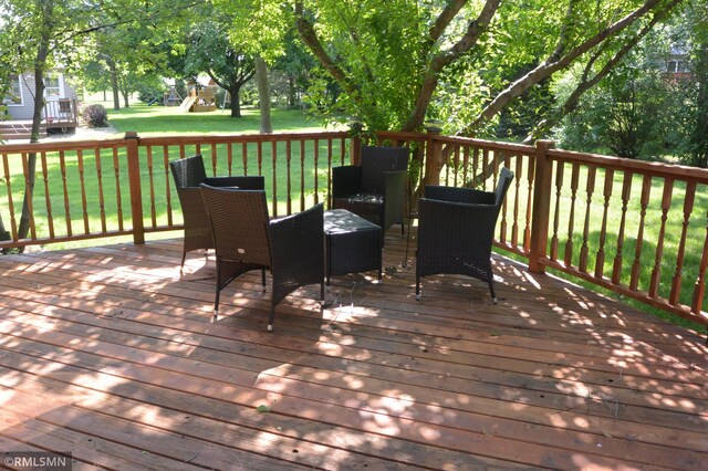1706 Fairway Dr, Glencoe, MN 55336 - wooden terrace featuring outdoor dining area, a playground, and a lawn