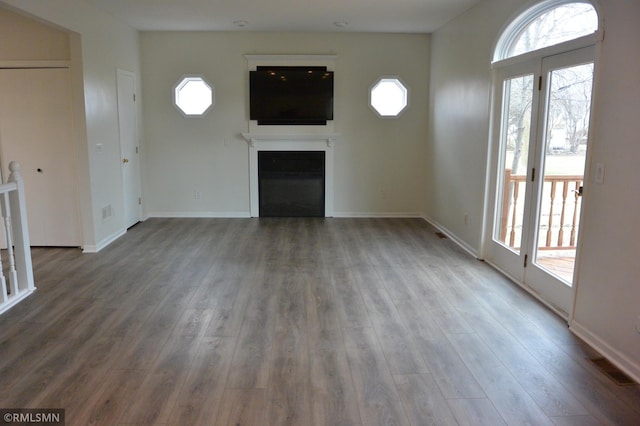 1706 Fairway Dr, Glencoe, MN 55336 - unfurnished living room featuring healthy amount of natural light, a fireplace, and wood finished floors
