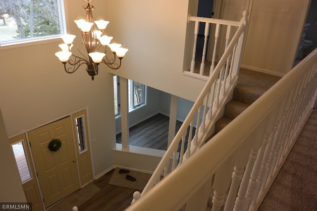 1706 Fairway Dr, Glencoe, MN 55336 - staircase featuring a chandelier, baseboards, a high ceiling, and wood finished floors