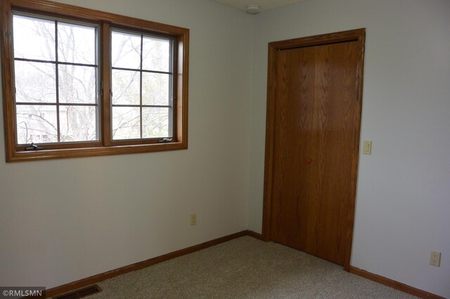 1706 Fairway Dr, Glencoe, MN 55336 - unfurnished bedroom featuring light colored carpet, baseboards, and a closet