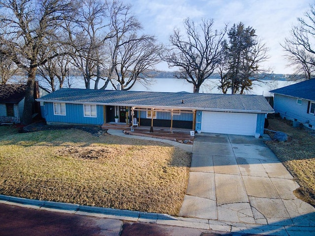 ranch-style house with a garage, driveway, a front yard, and covered porch