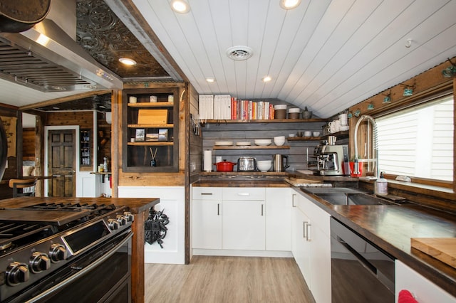 kitchen featuring open shelves, dishwasher, a sink, wall chimney range hood, and double oven range