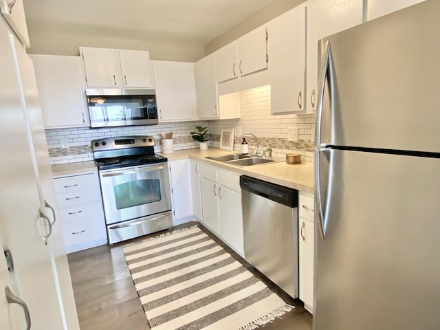 kitchen with a sink, appliances with stainless steel finishes, tasteful backsplash, and light countertops