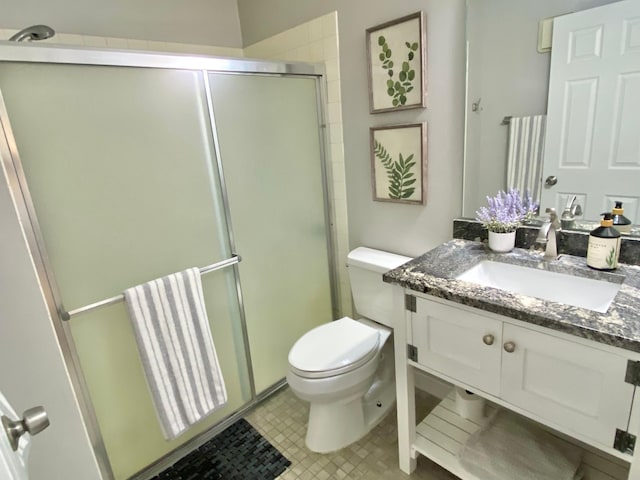 bathroom with vanity, a stall shower, and toilet