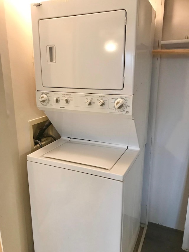 clothes washing area with stacked washer / drying machine and laundry area