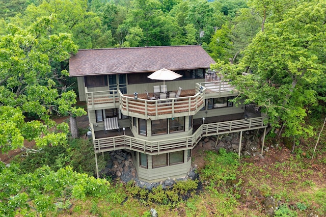 1109 Hamilton St, Saint Croix Falls, WI 54024 - rear view of house with a shingled roof, a deck, and a forest view