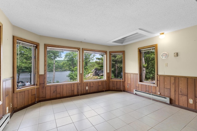 1109 Hamilton St, Saint Croix Falls, WI 54024 - unfurnished room with a baseboard radiator, a textured ceiling, wainscoting, wood walls, and a water view