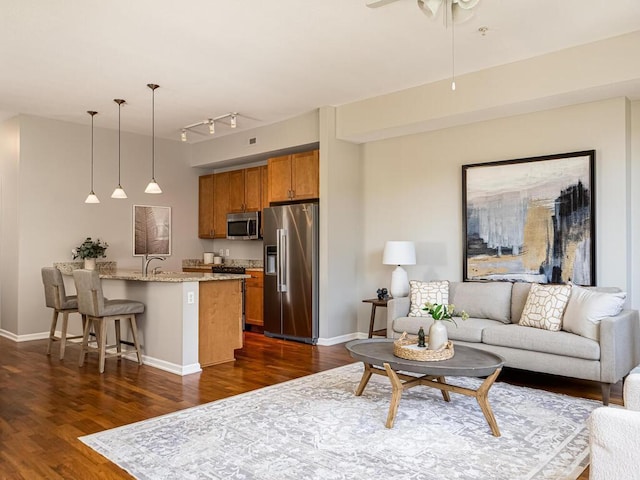 4730 Park Commons Dr Unit 215, Saint Louis Park, MN 55416 - living room with dark wood-style flooring, rail lighting, baseboards, and a ceiling fan