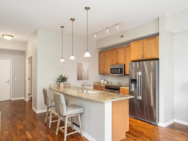 4730 Park Commons Dr Unit 215, Saint Louis Park, MN 55416 - kitchen featuring appliances with stainless steel finishes, a peninsula, dark wood-style flooring, brown cabinetry, and a sink