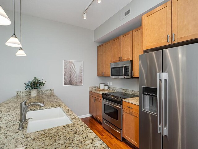 4730 Park Commons Dr Unit 215, Saint Louis Park, MN 55416 - kitchen featuring stainless steel appliances, a sink, dark wood-style floors, light stone counters, and pendant lighting