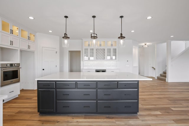 13937 Ember Ct, Apple Valley, MN 55124 - kitchen with oven, white cabinets, gray cabinetry, light wood-style flooring, and recessed lighting