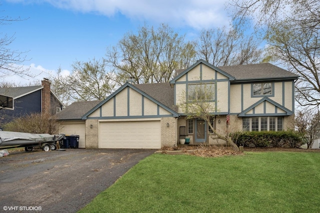 tudor house with driveway, a front yard, a garage, brick siding, and stucco siding