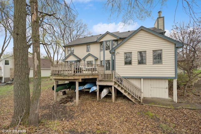 rear view of property with stairway, a wooden deck, and a chimney