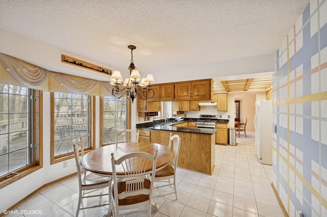 dining space with baseboards, a textured ceiling, light tile patterned flooring, and a chandelier