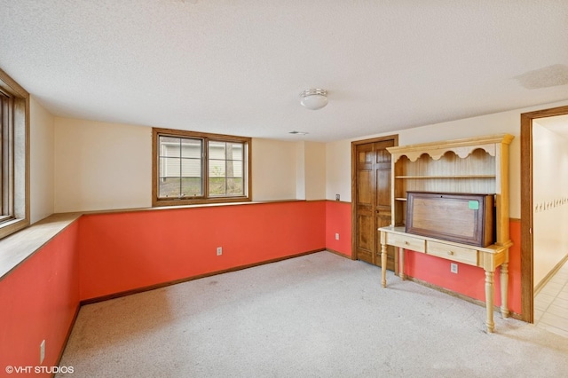 unfurnished living room featuring baseboards, carpet flooring, and a textured ceiling