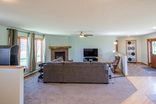 17367 Gull Lake Loop Rd NE, Bemidji, MN 56601 - living room with a baseboard heating unit, ceiling fan, a tile fireplace, wood finished floors, and a textured ceiling