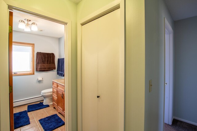 17367 Gull Lake Loop Rd NE, Bemidji, MN 56601 - bathroom featuring baseboard heating, toilet, vanity, and tile patterned floors