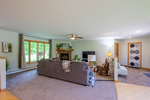 17367 Gull Lake Loop Rd NE, Bemidji, MN 56601 - living area featuring baseboard heating, a fireplace, ceiling fan, a textured ceiling, and wood finished floors