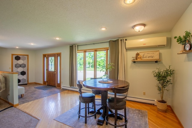 17367 Gull Lake Loop Rd NE, Bemidji, MN 56601 - dining space with a wall mounted air conditioner, a baseboard heating unit, a textured ceiling, wood finished floors, and baseboards