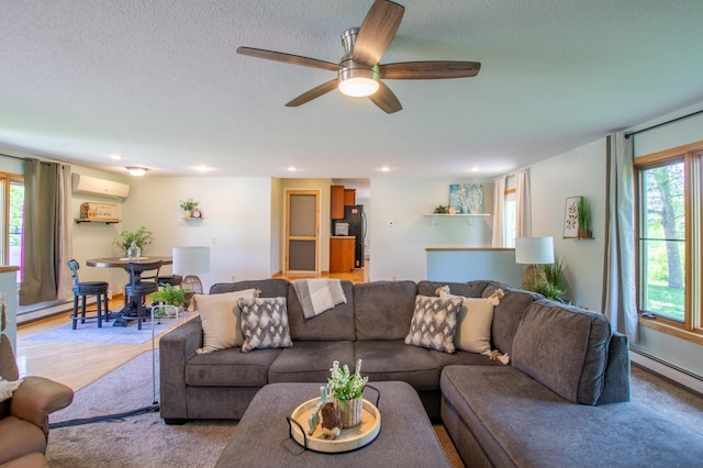 17367 Gull Lake Loop Rd NE, Bemidji, MN 56601 - living area with an AC wall unit, a ceiling fan, a textured ceiling, recessed lighting, and baseboard heating