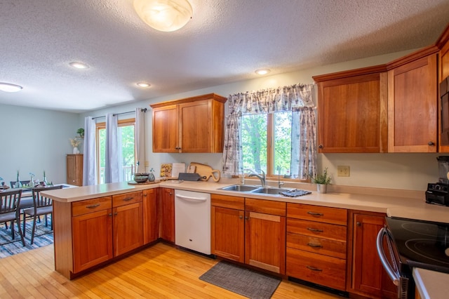 17367 Gull Lake Loop Rd NE, Bemidji, MN 56601 - kitchen with white dishwasher, a textured ceiling, a peninsula, a sink, and light countertops