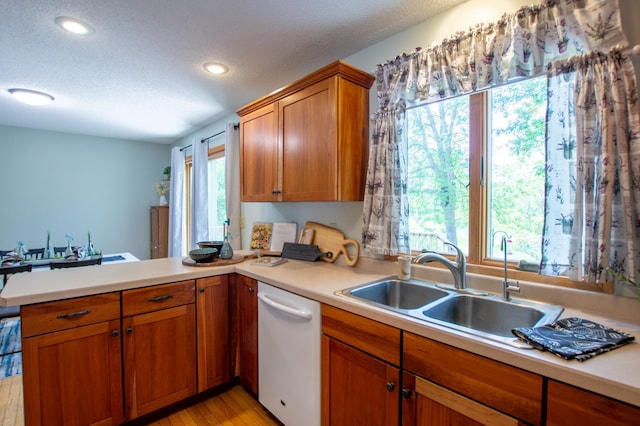 17367 Gull Lake Loop Rd NE, Bemidji, MN 56601 - kitchen featuring dishwasher, a sink, a peninsula, healthy amount of natural light, and a textured ceiling