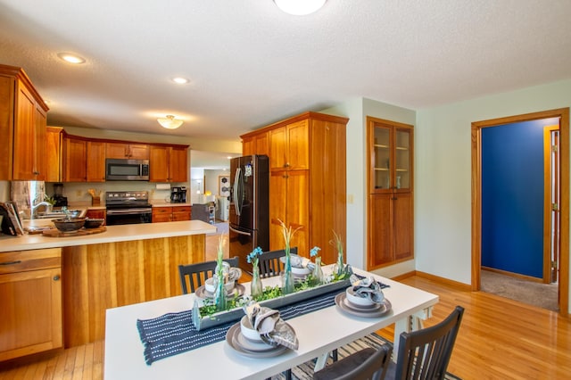 17367 Gull Lake Loop Rd NE, Bemidji, MN 56601 - kitchen with appliances with stainless steel finishes, light countertops, light wood finished floors, a peninsula, and brown cabinets