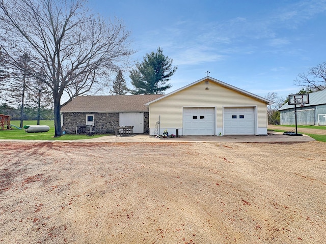 ranch-style house featuring a garage, a playground, a front yard, and stone siding