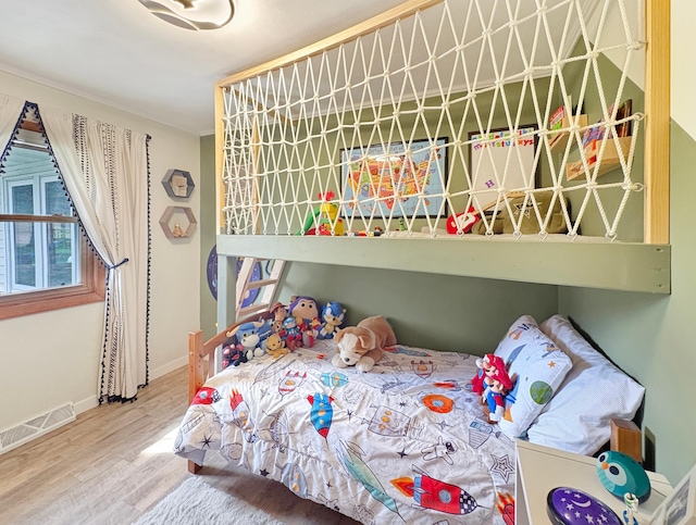 bedroom featuring baseboards, wood finished floors, and visible vents