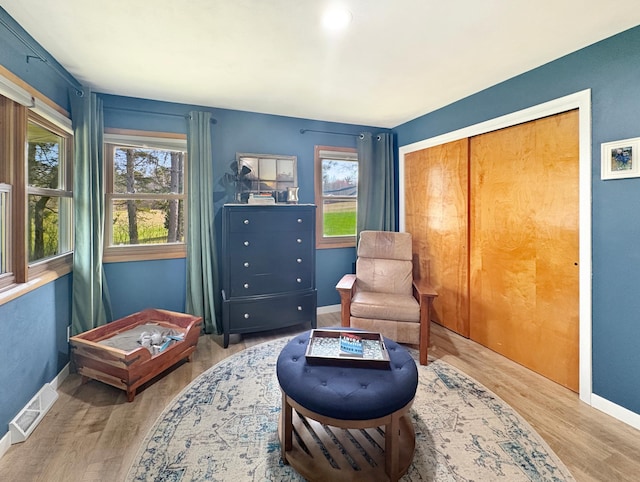 sitting room featuring baseboards, wood finished floors, and visible vents