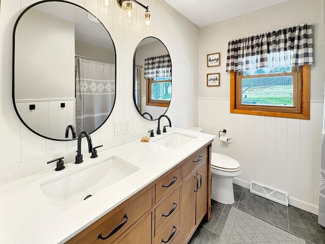 bathroom with visible vents, plenty of natural light, and a sink