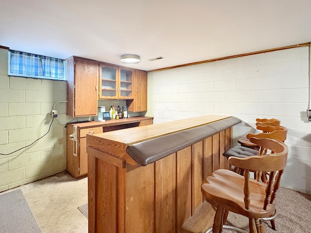 bar featuring concrete block wall, a dry bar, and visible vents