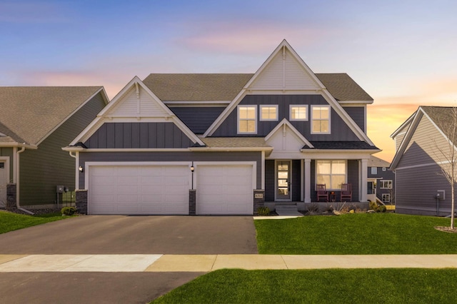 4312 Picket Way N, Woodbury, MN 55129 - view of front of property with board and batten siding, asphalt driveway, a yard, and a shingled roof