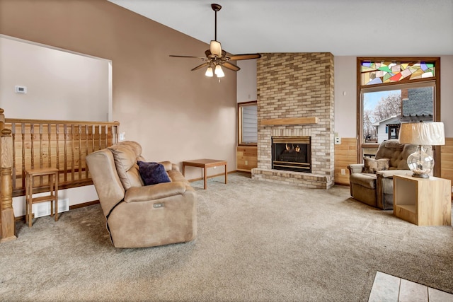 carpeted living area featuring lofted ceiling, a ceiling fan, visible vents, and a fireplace